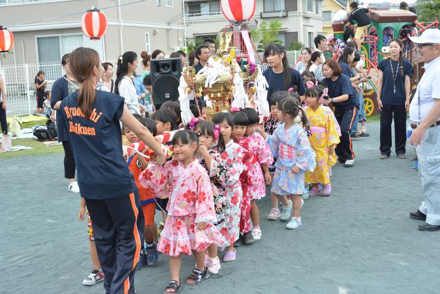 竜王西保育園の園庭にて神輿を引いている園児たちと先生の写真