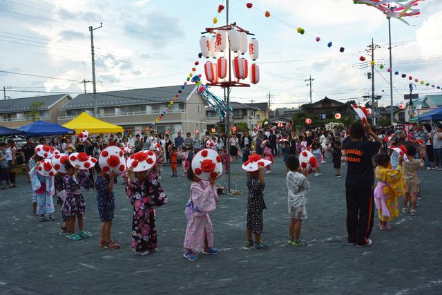 竜王西保育園の園庭にて簿盆踊りを踊っている園児たちを先生の写真