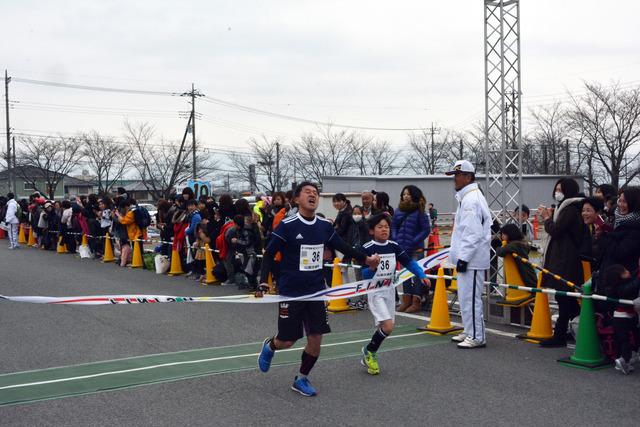 (写真)一緒にゴールテープを切る親子