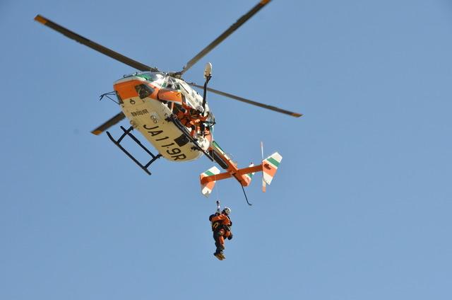 ヘリコプターに隊員と救助された人が吊られている写真