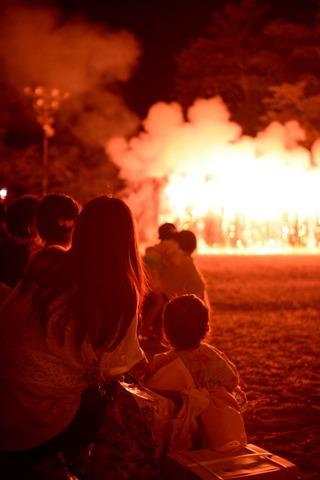 花火大会を楽しむ家族連れの後姿の写真