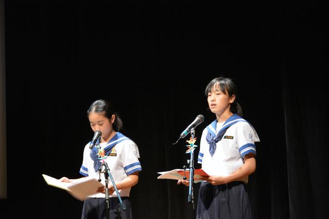 2人の女子学生が壇上で朗読をしている写真