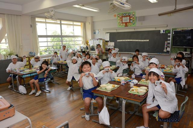 子供達が「9月1日は 甲斐市の14さいの 誕生日です」とメッセージが書かれた味付け海苔を持っている写真1