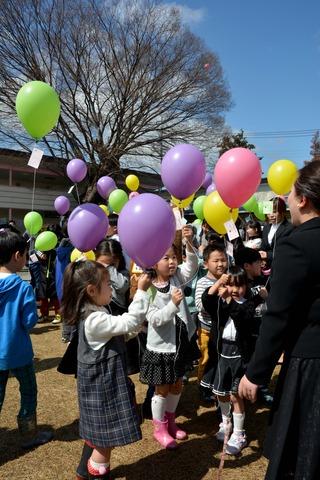 メッセージをつけた風船を持つ園児たちの写真