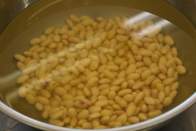 ボールに入れて水に浸した大豆の写真