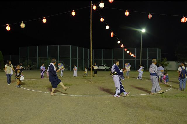 輪になって盆踊りを楽しむ人々の写真