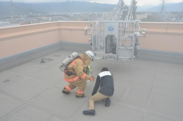 (写真)屋上で高所救助される人