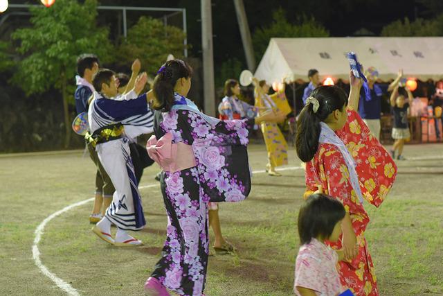 浴衣姿で盆踊りを楽しむ人々の写真