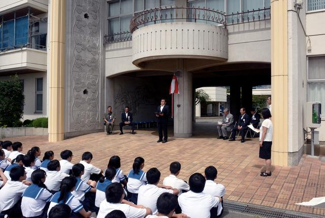 除幕式で中学生が座って話を聞いている写真