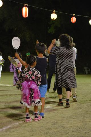 小学生くらいの子どもたちが盆踊りを踊っている写真