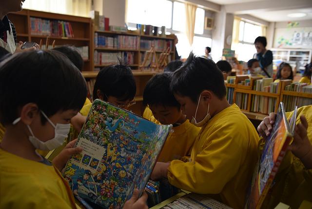図書館で本を手に取る園児たちの写真