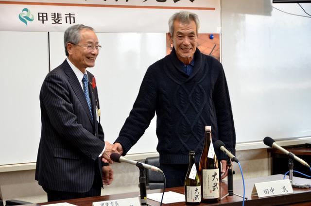 記者会見にて保坂武市長と田中泯さん二人が握手している写真