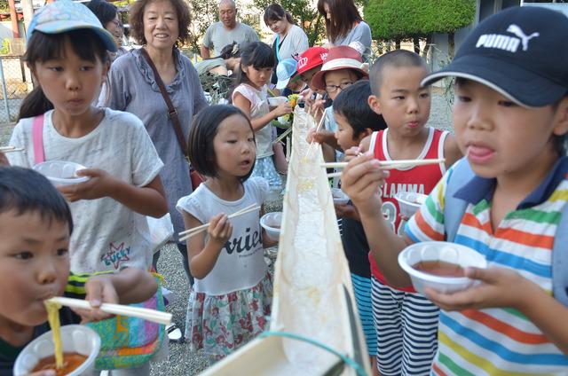 流しそうめんを楽しんでいる子どもたちの写真