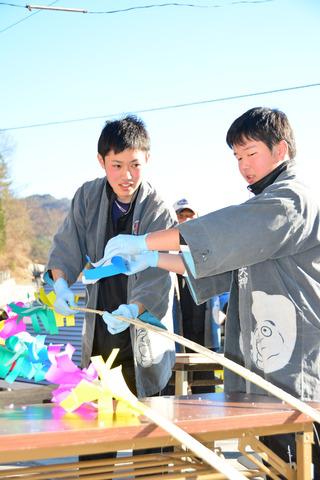 青年会のメンバーが竹に飾り付けをしている写真