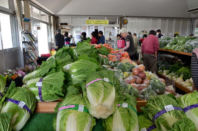 (写真)山積みになった白菜と奥のレジ前は長蛇の列