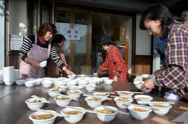 (写真)具だくさんの豚汁を振る舞う人たち