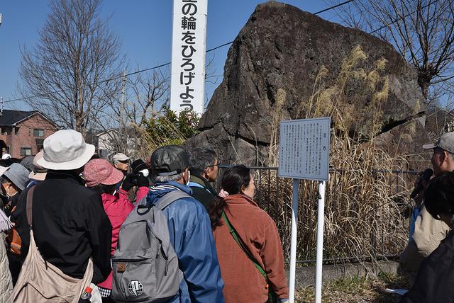 市役所双葉支所近くの「泣石」を見学している人たちの写真