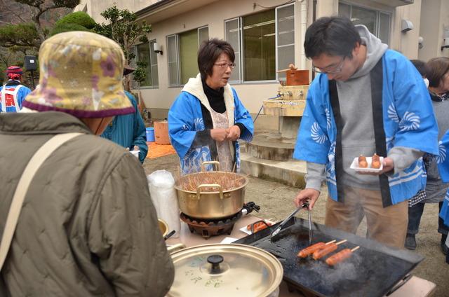 フランクフルトを鉄板で焼いている男性の写真