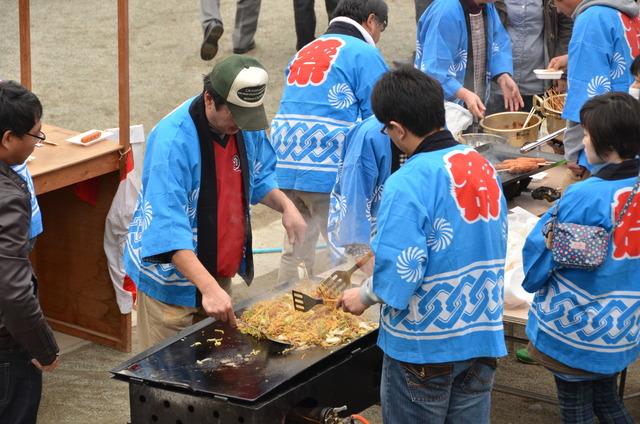 やきそばを鉄板で焼いている男性の写真