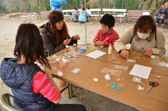 テーブルで作業をしている子どもと大人の写真