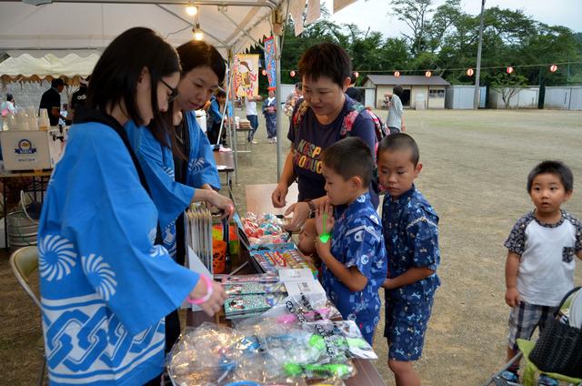 屋台で景品を選ぶ子ども達の写真