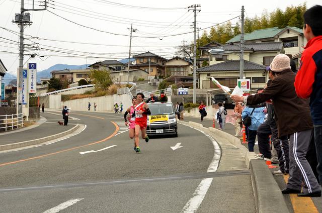 駅伝の2人の選手が競り合って走っている写真