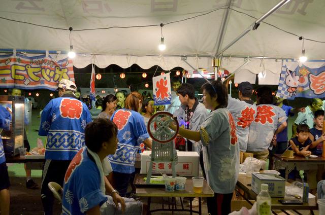 屋台でかき氷を作る人々の写真