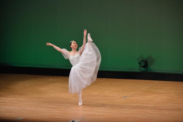 舞台の上で、一人のバレリーナが踊っている写真