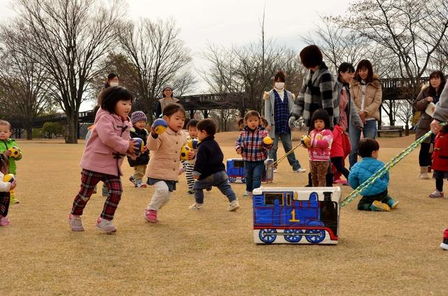 機関車トーマスが描かれた箱をボールを持った子供たちが追いかけている写真