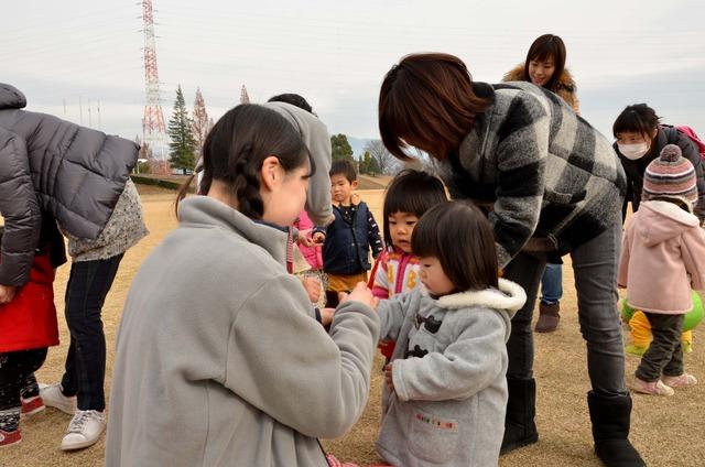 子どもたちが先生から手にスタンプを押してもらっている写真