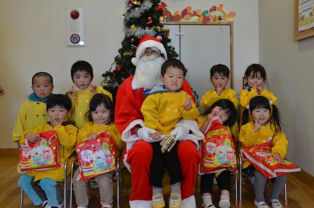 9人の園児とサンタさんと一緒に記念撮影をしている写真