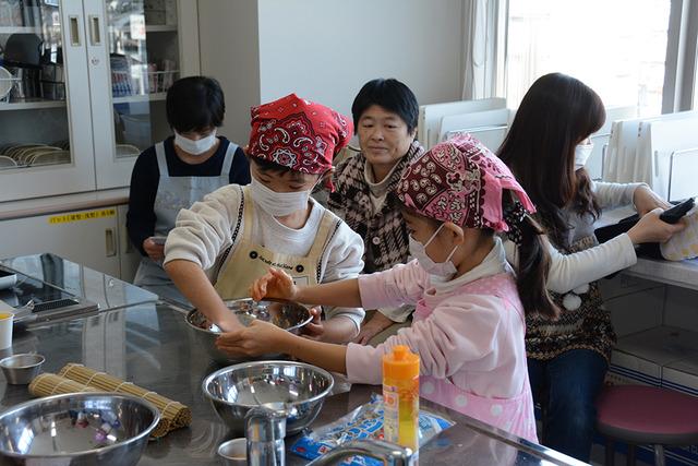 (写真)子どもたちだけで料理をしているところを見守る保護者