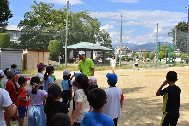 コーチの周りに集まり話を聞いている子供たちの写真