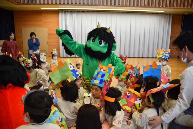 可愛らしい大きな緑鬼と園児の写真