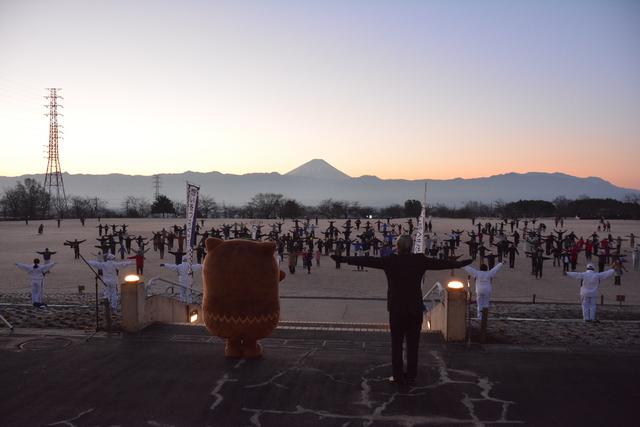 総合公園で広がって体操をするたくさんの参加者の写真