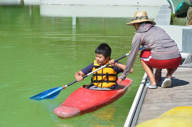 男の子が先生に説明を受けながら、カヌーを漕ぐ様子の写真