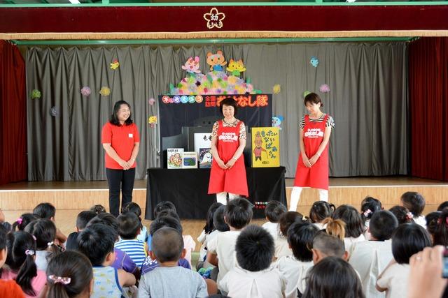 園児たちの前で先生と朗読サークル「みずすましの会」のメンバー2人が挨拶している写真