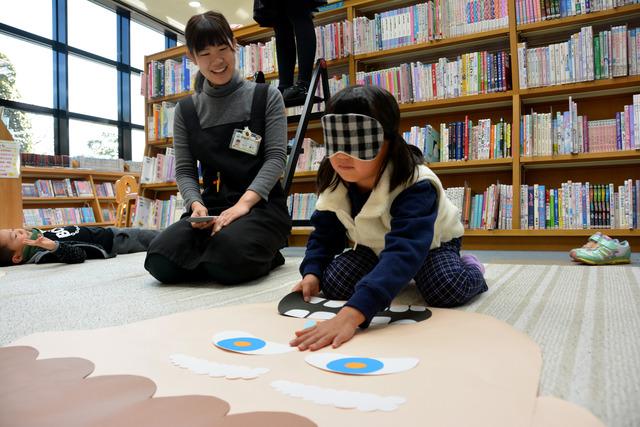 竜王図書館にて目隠しをしながら巨大ふくわらいをしている女の子の写真