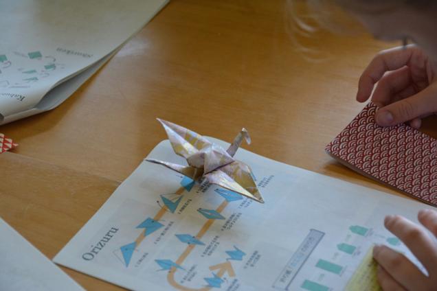 折り鶴の折り方が書かれた紙と完成した折り鶴の写真