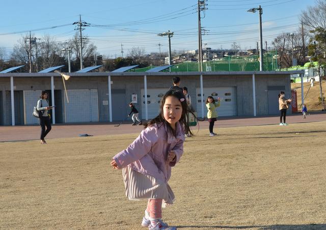 作った竹とんぼを飛ばす女の子の写真