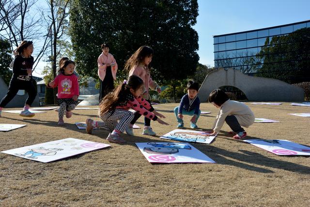 甲州弁ビックかるたに参加している子供たちが一つのかるたを取ろうとしている写真