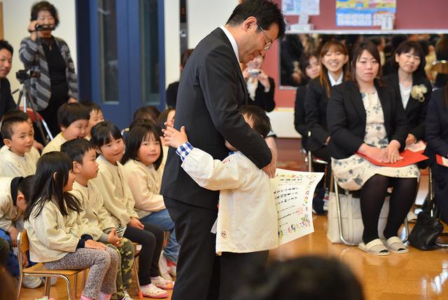 お父さんと抱き合う園児の写真