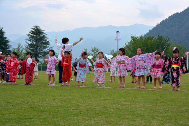 浴衣を着た子どもたちが両手を挙げて踊っている写真