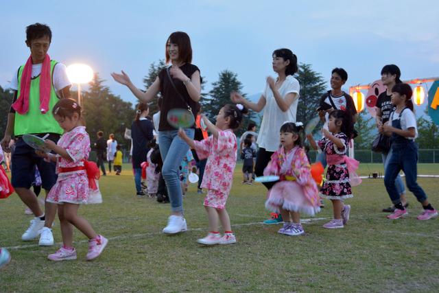 浴衣を着た子どもたちと保護者が並んで踊っている写真