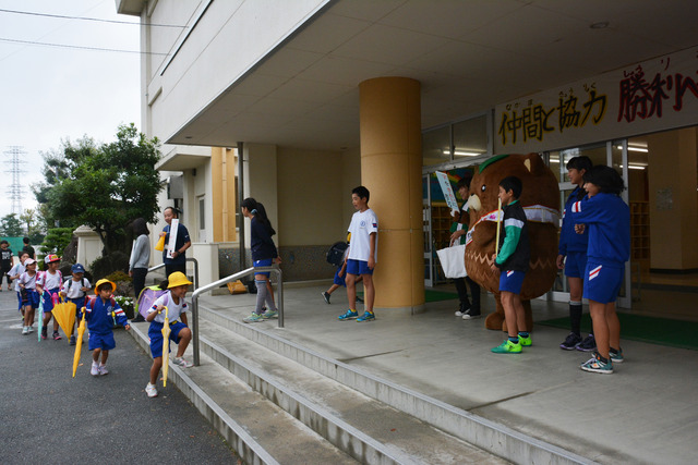 (写真)学校の玄関に立ち子どもたちを迎えるやはたいぬ