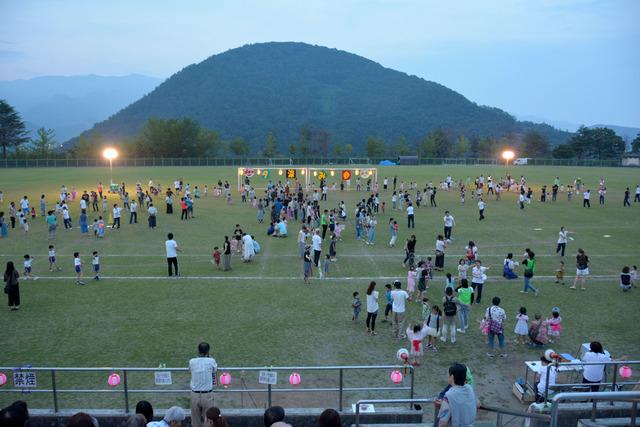 2つの大きな円になって親子で盆踊りを踊っている写真