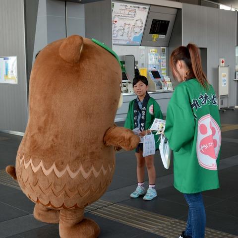 ゆるキャラのやはたいぬと緑の半被を着た女性と女の子の写真