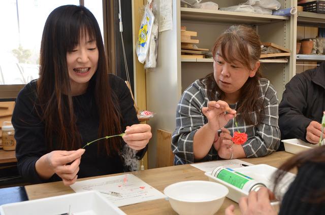 凍った花を手で触っている参加者の写真