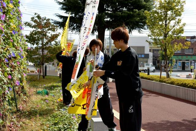 (写真)のぼり旗を設置するQB選手