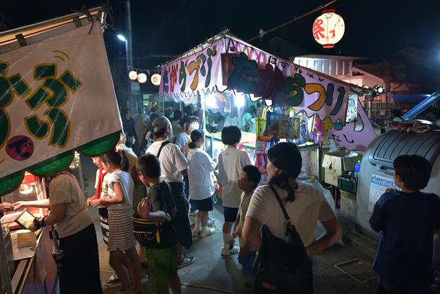 露店に多くの人々が集まっている様子の写真